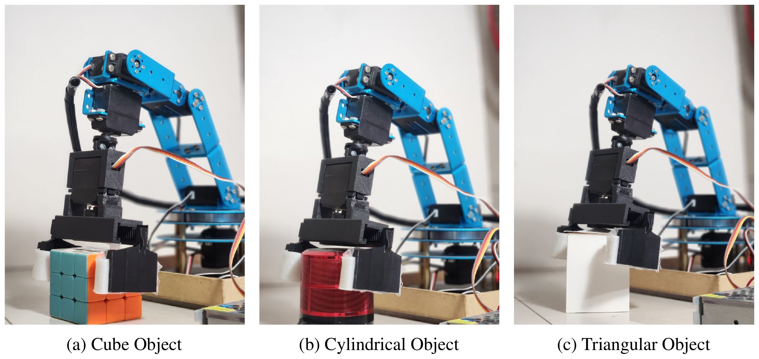 The arm with its soft gripper around a cube, a cylinder and a triangular prism