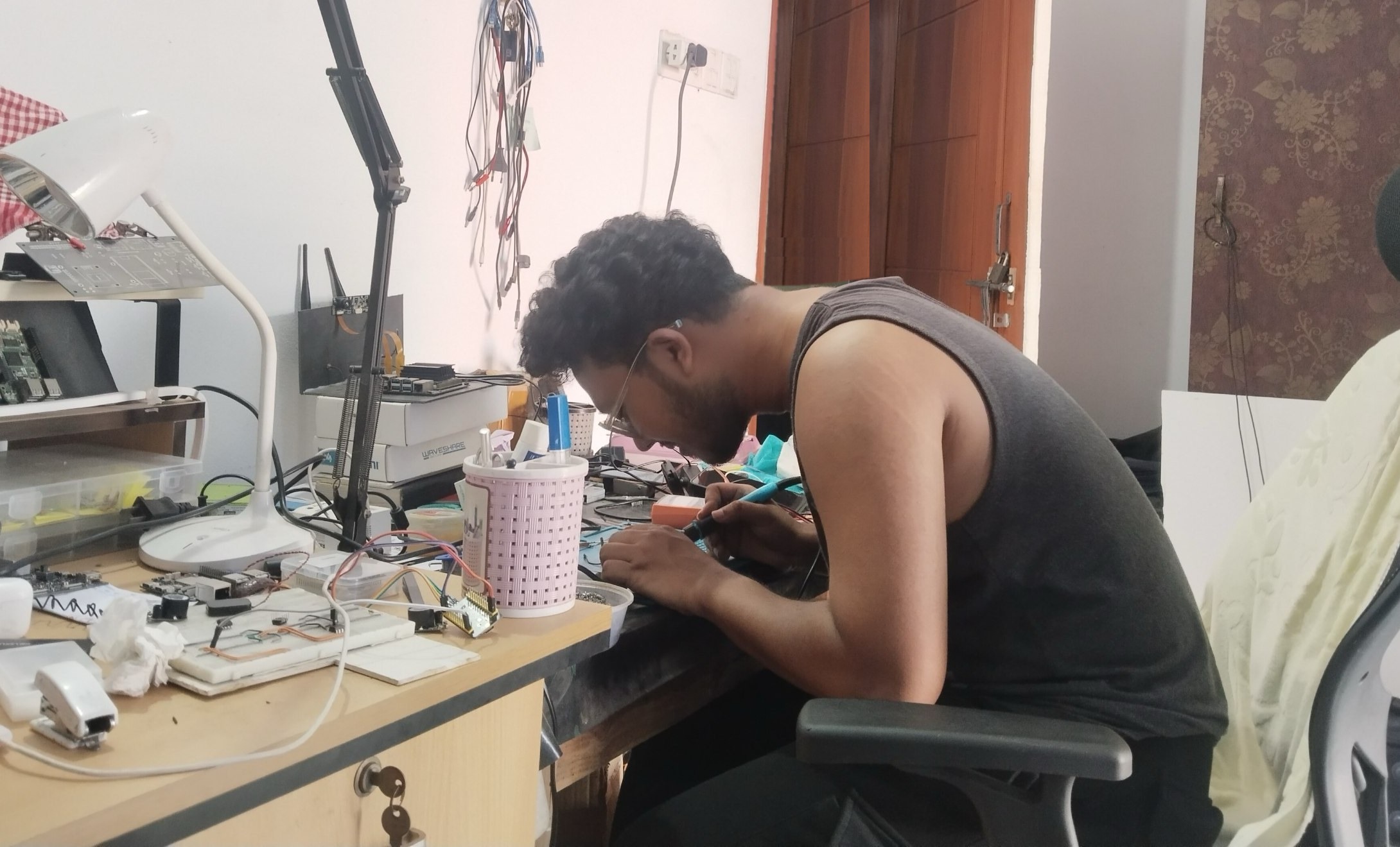 AIoT developer soldering a sensor harness at our electronics bench